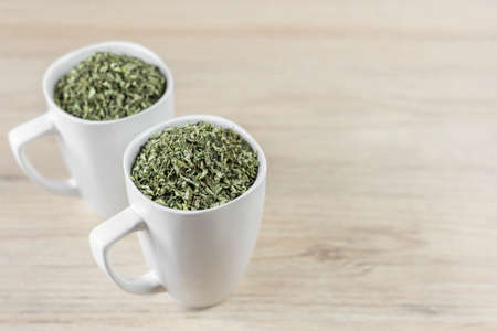 white cup with moringa leaves on wooden backgroundの写真素材