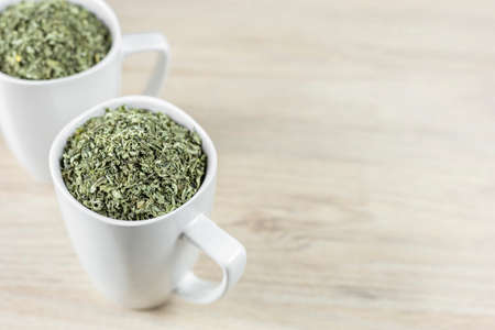 white cup with moringa leaves on wooden backgroundの写真素材