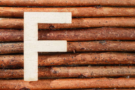 Letter F of wood-made alphabet, top view and space for text
