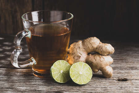 Glass with ginger tea on old wood, space for textの写真素材
