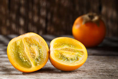 Fruit of lulo or naranjilla on wood subtropical perennial plant of northwestern South America, close-up image, Solanum quitoenseの写真素材