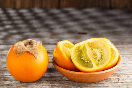 Fruit of lulo or naranjilla on wood subtropical perennial plant of northwestern South America, close-up image, Solanum quitoenseの写真素材