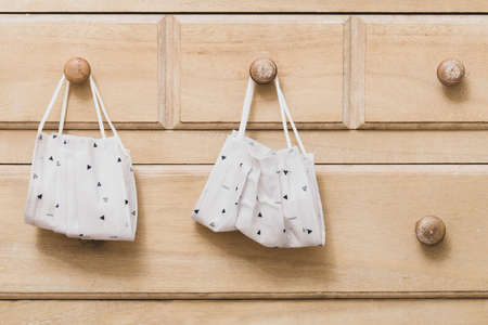 Surgical mask, or face mask, hangs from dresser, daily use of face mask