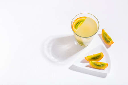 glass with juice and slices of lulo fruit, on the table, Solanum quitoenseの写真素材