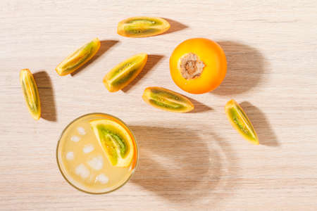 glass with juice and slices of lulo fruit, on the table, Solanum quitoenseの写真素材