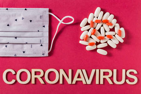 Coronavirus word written with wooden letters and medicine tablets, top viewの写真素材