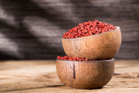 annatto seeds in bowl on wooden backgroundの写真素材