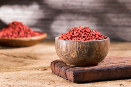 annatto seeds in bowl on wooden backgroundの写真素材