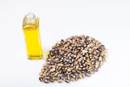 castor oil and grains in bowl isolated on white background image close-up