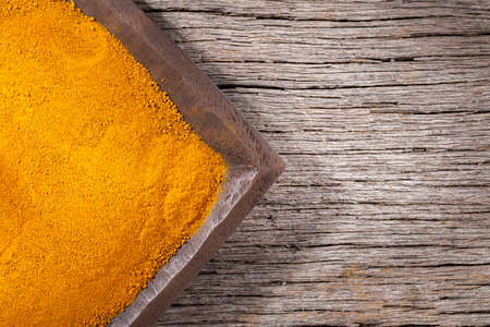Turmeric powder in bowl on wooden background (Curcuma longa)の写真素材