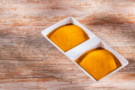 Turmeric powder in bowl on wooden background (Curcuma longa)の写真素材