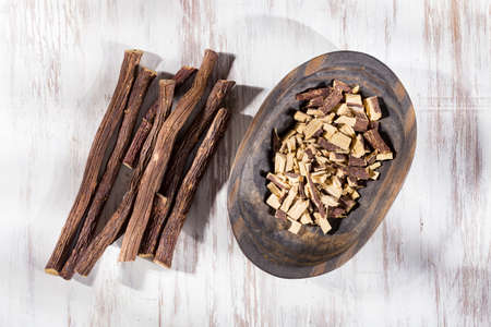 Licorice root in bowl on wooden background close-up imageの写真素材