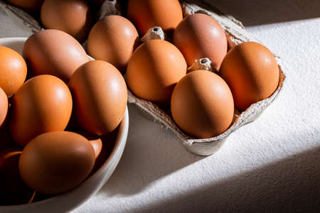 pile of chicken eggs in basket, on white table