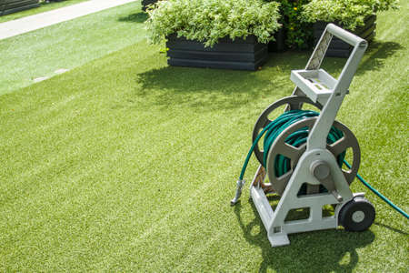 garden watering irrigation hose on the lawnの写真素材