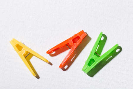 Colorful plastic clothespins for hanging clothes on white background