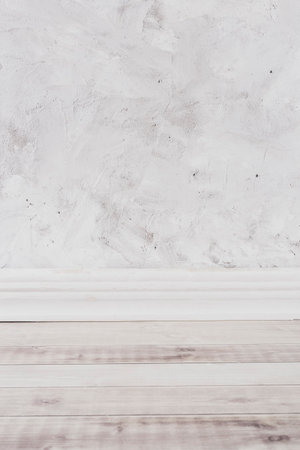 wooden floor with plaster molding and gray and white textured cement backgroundの写真素材