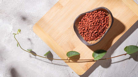 achiote grains in wooden bowl on white background (Bixa orellana)の写真素材