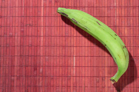 Male banana on red wooden background, space for textの写真素材