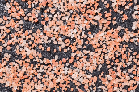 Himalayan pink salt crystals on black background, space for text