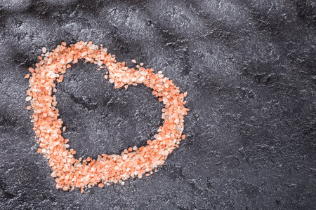Himalayan pink salt crystals on black background, space for textの写真素材