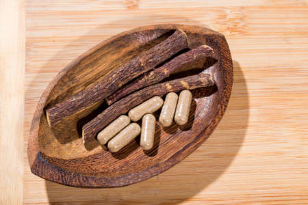 licorice root and tablets on black backgroundの写真素材