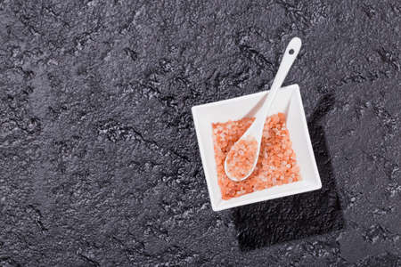 pink himalayan salt, in bowl on black background