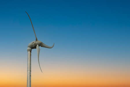 small wind turbine in sunset sky, clean energy for peopleの写真素材
