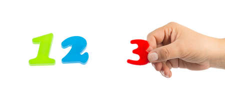 Woman's hand holding plastic number 3 symbol, close up imageの写真素材