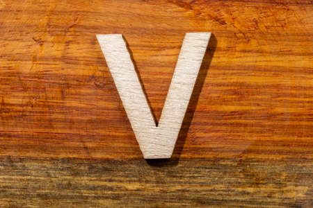 Wooden letters V on wooden background, top viewの写真素材