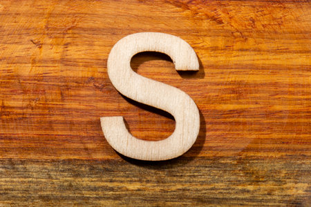 Wooden letters S on wooden background, top viewの写真素材