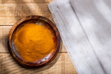 Turmeric powder in bowl on the table, top view.の写真素材