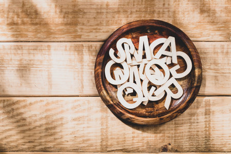 Alphabet letters in a wooden bowl on the table, space for textの写真素材