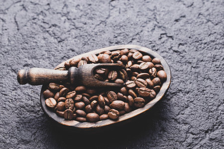 Roasted coffee beans with wooden spoon, closeup image, space for textの写真素材