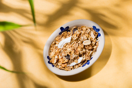 plate with healthy granola on yellow background, top viewの写真素材