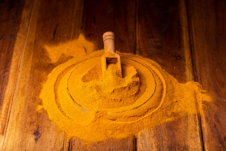 Turmeric Powder in a Wooden Spoon and Bowlの写真素材