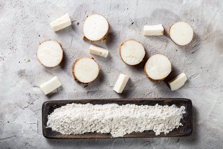 pile of cassava root and cassava flour on a gray and white textured background (Manihot esculenta)の写真素材