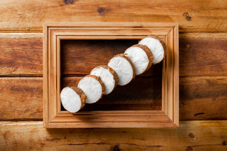 cassava pile, yucca, on a background of rustic wood (Manihot esculenta)の写真素材