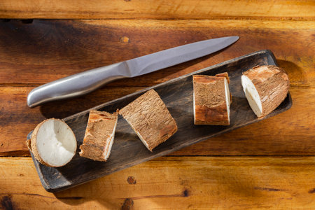 cassava pile, yucca, on a background of rustic wood (Manihot esculenta)の写真素材