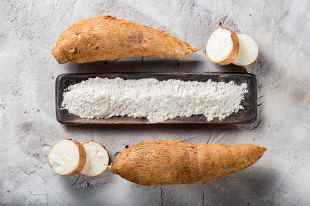 pile of cassava root and cassava flour on a gray and white textured background (Manihot esculenta)の写真素材