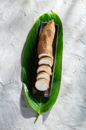 cassava root pile on a gray and white textured background (Manihot esculenta)の写真素材