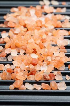 heap of Himalayan salt grains, on the black panの写真素材