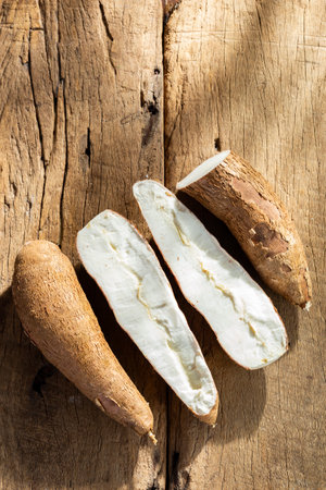 cassava pile, yucca, on a background of rustic wood (Manihot esculenta)の写真素材