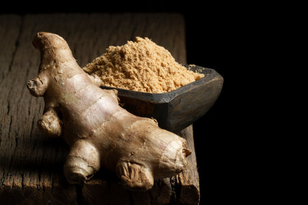 Ginger root and powder on a rustic wood, close-up image