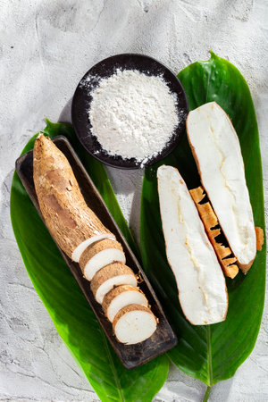 pile of cassava root and cassava flour on a gray and white textured background (Manihot esculenta)の写真素材