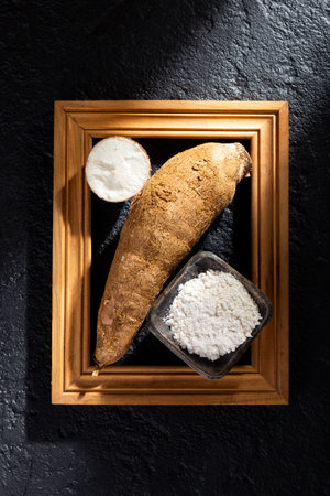 pile of cassava and cassava flour on dark background (Manihot esculenta)の写真素材