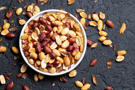 Pile of roasted peanuts on black background, space for textの写真素材