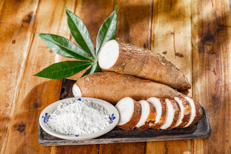 pile of cassava, cassava and cassava flour on a background of rustic wood (Manihot esculenta)の写真素材