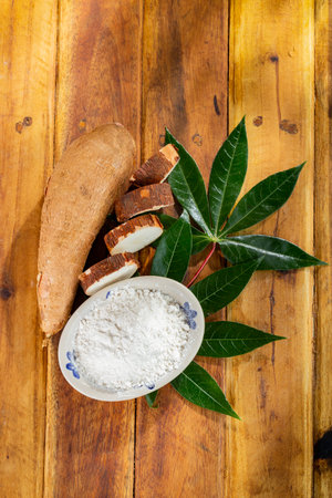 pile of cassava, cassava and cassava flour on a background of rustic wood (Manihot esculenta)の写真素材