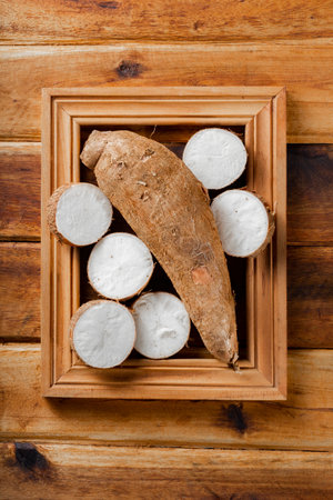 cassava pile, yucca, on a background of rustic wood (Manihot esculenta)の写真素材