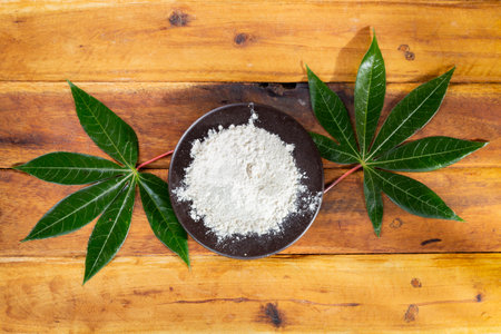 pile of cassava, and cassava flour on a background of rustic wood (Manihot esculenta)の写真素材